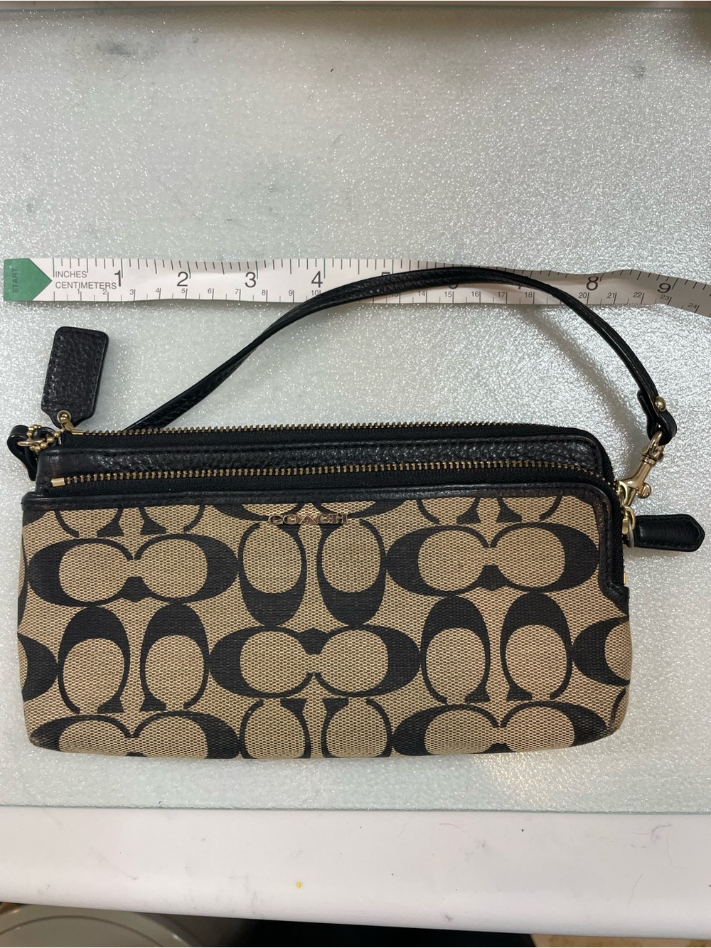 Authentic Coach signature wristlet/clutch in classic khaki and black.